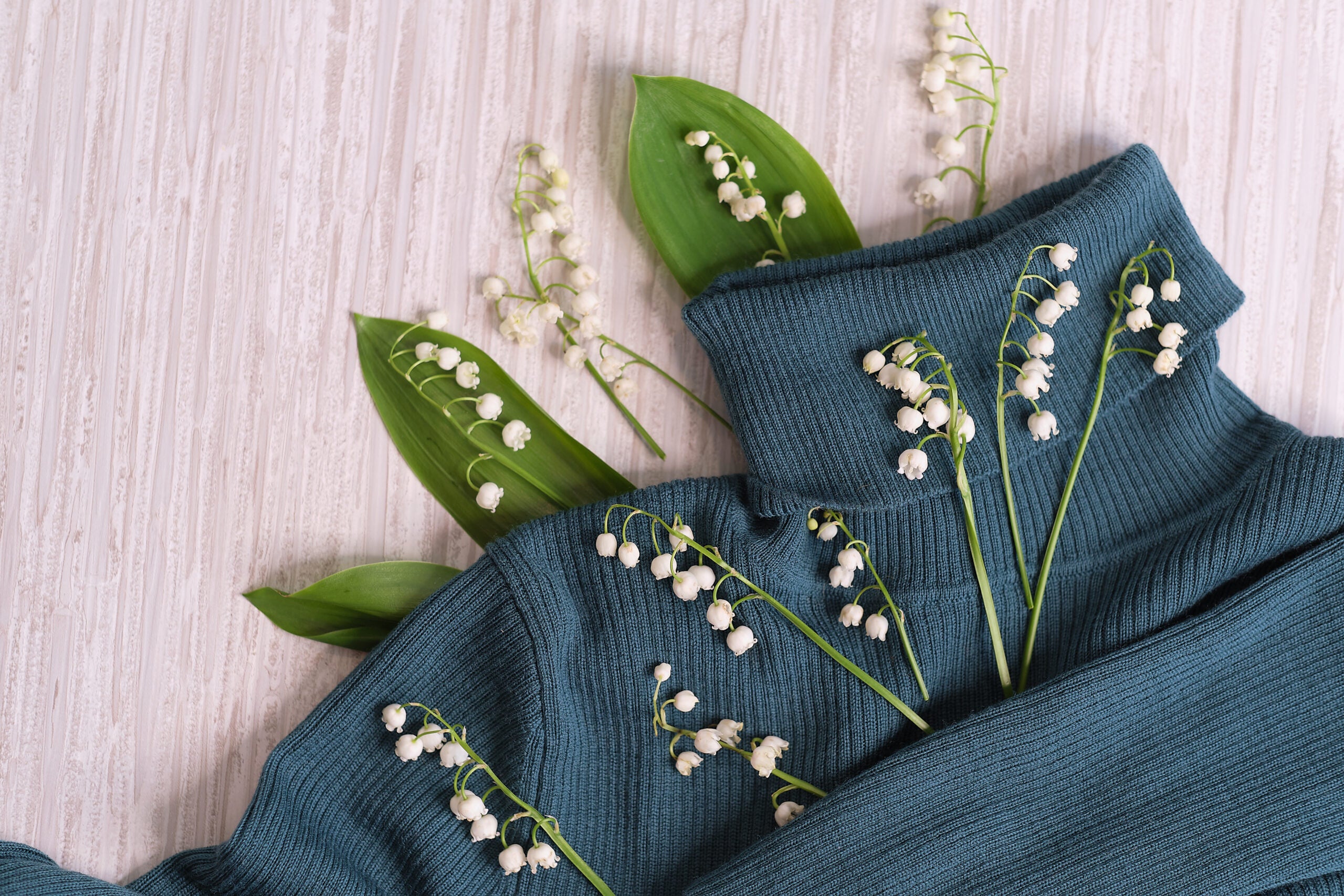 flowers, and clothes on a wooden background. Concept for organic, recycled clothes and eco-friendly, ecological fashion. Eco friendly fabric shop. flowers, and clothes on a wooden background.