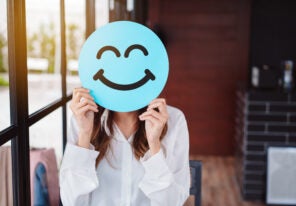 woman holding blue happy smile face on paper cut,