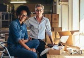 man and woman smiling next to cardboard boxes