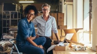 man and woman smiling next to cardboard boxes