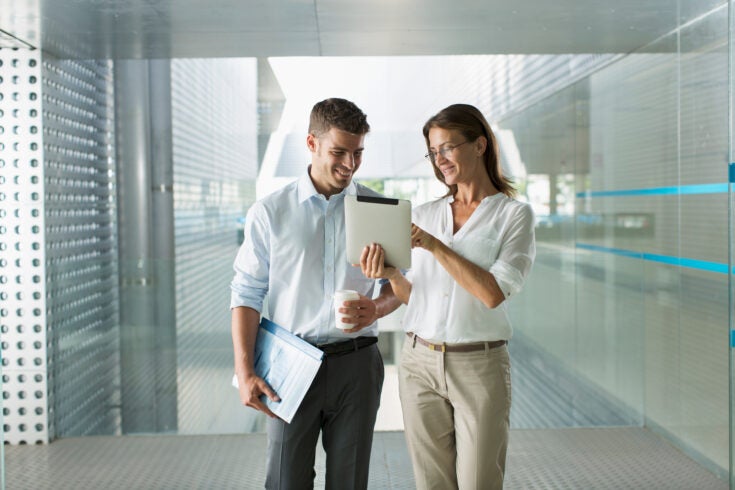 Corporate business people using digital tablet in modern office